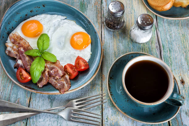 istock Fried eggs,  bacon, tomato, toast and a cup of coffee 1199042127