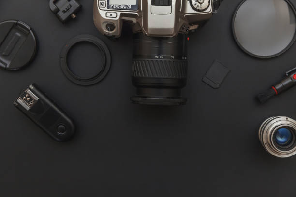 istock Photographer workplace with dslr camera system, camera cleaning kit, lens and camera accessory on dark black table background. Hobby travel photography concept. Flat lay top view copy space 1199042366