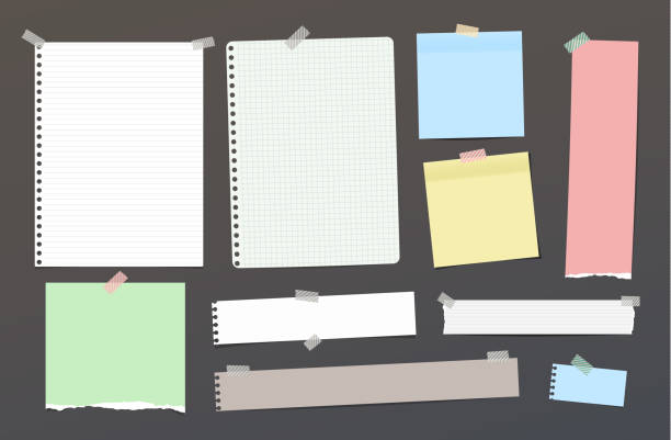 istock Ripped blank ruled note, notebook, copybook paper strips, sheets stuck with colorful sticky tape on dark background. 1199044550