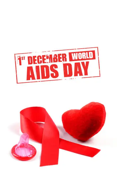 Aids ribbon, condom and heart on white background.