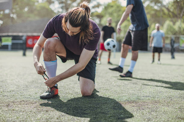 istock Male soccer player tying shoelace 1199048567