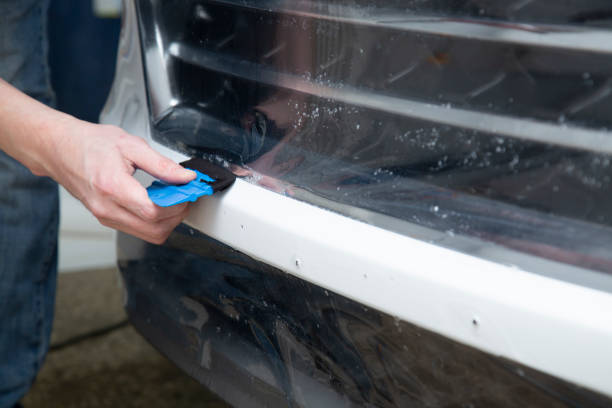 istock Installing a protective film on the car body 1199049081