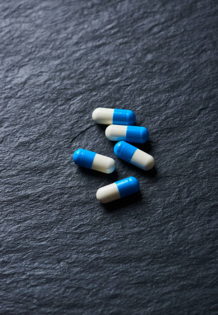 istock Sports Supplements (creatine capsules) on dark stone background. 1199052357