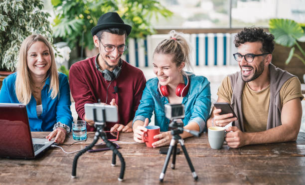 istock Young friends group sharing info on streaming platform with webcam - Startup marketing concept with millennial guys and girls having fun vlogging live talk feed on social media network - Bright filter 1199053965