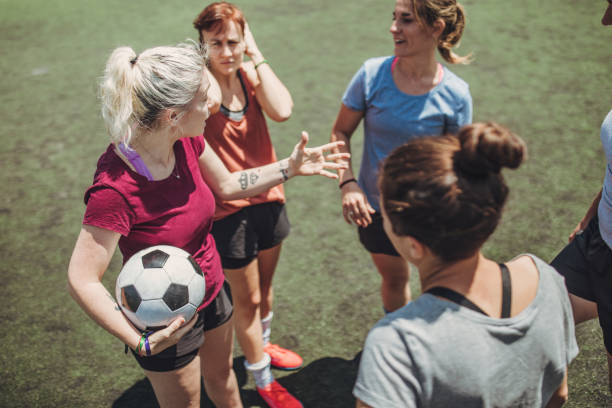 istock Women standing on a soccer playing field 1199054417