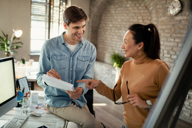 istock Happy entrepreneurs cooperating while working on business reports in the office. 1199056856