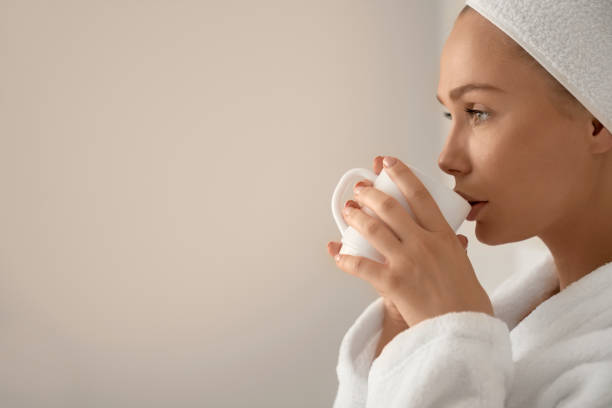 istock Girl in bathrobe drinking coffe in bed. 1199057920