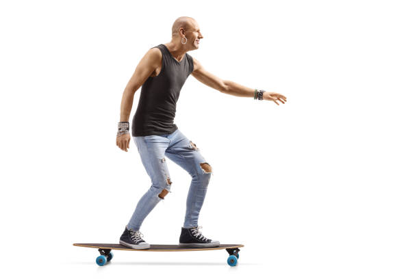 istock Bald male hispter riding a longboard 1199059751