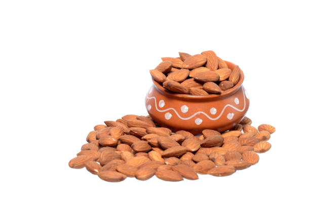 istock Almonds in a clay pot isolated on a white background 1199060359