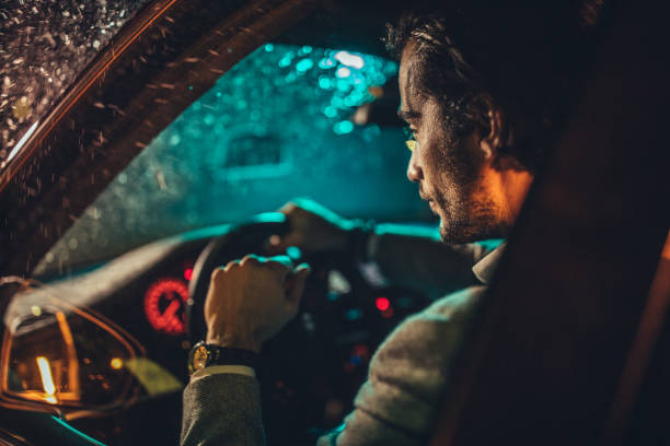 istock Businessman Driving A Car In Night 1199061552