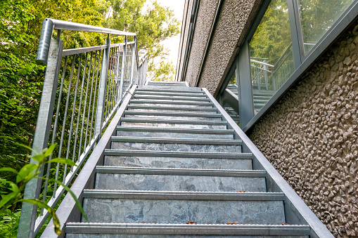 Berlin, Berlin/Germany - 07.08.2019: A fire escape outside of an office building made of hot-dip galvanized metal on a house wall at the back of the building for evacuation in case of fire.