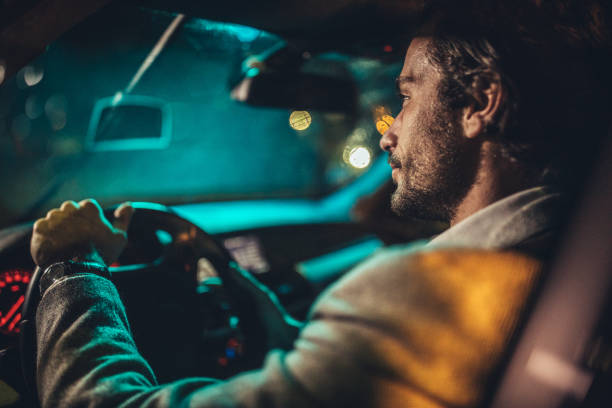 бизнесмен за рулем автомобиля в ночное время - car speed lifestyles night стоковые фото и изображения