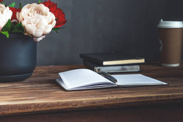 istock Still life  bouquet flowers in pot, notebook and coffee 1199061806