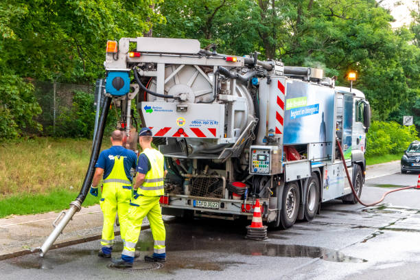 Sewer cleaning Berlin, Berlin/Germany - 06.08.2019: A suction truck of the Berlin waterworks cleaning sewers and gullies with workers at work flushing water stock pictures, royalty-free photos & images