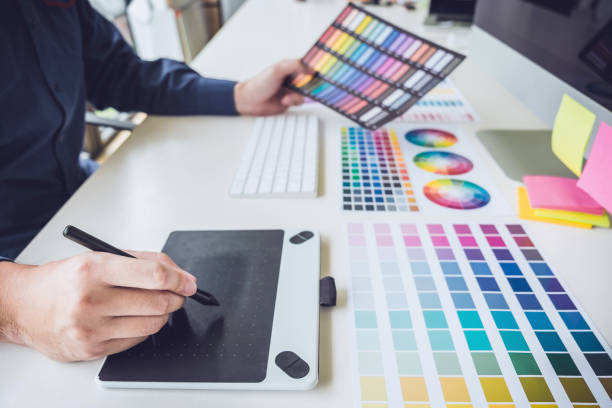 istock Image of male creative graphic designer working on color selection and drawing on graphics tablet at workplace with work tools and accessories 1199062656