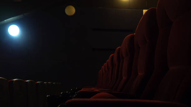 istock Red chairs in cinema in dark, lit lantern. Selective focus 1199063883