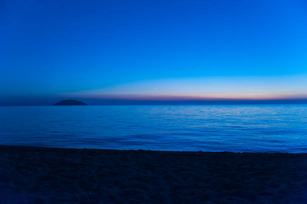 istock blue sea at sunset with island and moon 1199066947