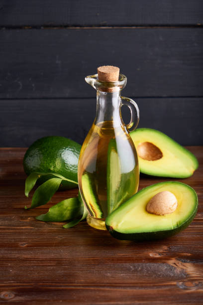 Healthy Avocado oil in glass bottles. Dark background Copy space stock photo