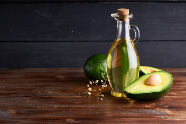 Healthy Avocado oil in glass bottles. Dark background Copy space stock photo