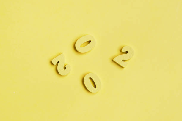 istock Wooden figures 2020 in a scattered state on a yellow background. 1199068374