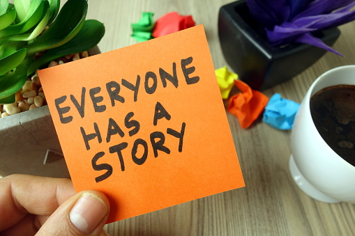Slogan everyone has a story handwritten on sticky note, business concept