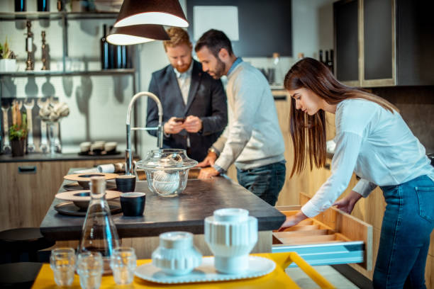 istock Customers looking at the kitchen island and cabinet features in a kitchen equipment store 1199072600