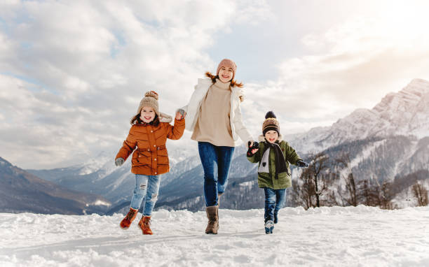 冬の散歩で楽しんでいる幸せな家族の母と子供たち - fun walk ストックフォトと画像
