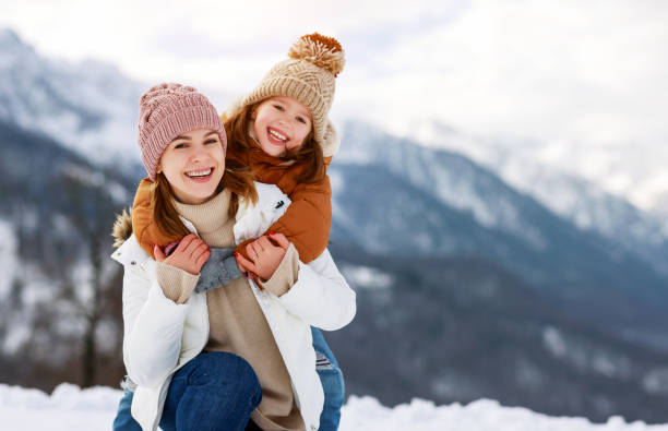 冬の散歩で遊ぶ幸せな家族の母と子供 - family with two children family park child ストックフォトと画像