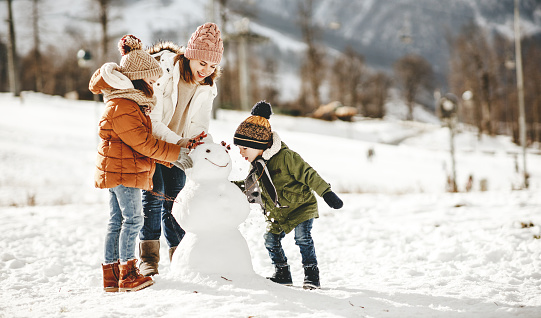 feliz madre de la familia y los niños divirtiéndose en el paseo de invierno photo
