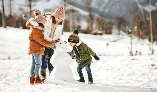 happy family mother and children having fun on winter walk happy family mother and children daughter and son having fun on winter walk snowman stock pictures, royalty-free photos & images