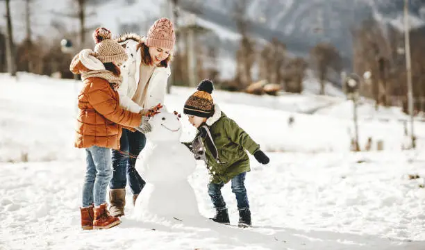 Photo of happy family mother and children having fun on winter walk