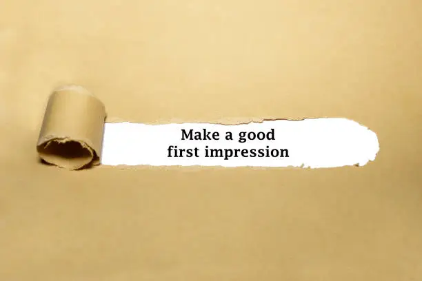 Motivational advice Make A Good First Impression appearing behind ripped brown paper.