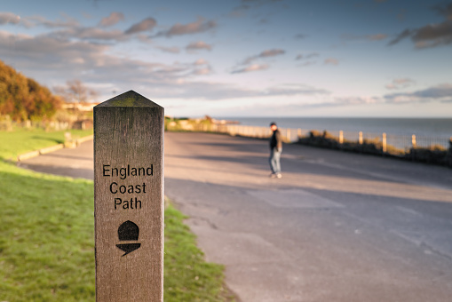 Wooden stake with England Coast Path sign on the promenade in Ramsgate with copy space.