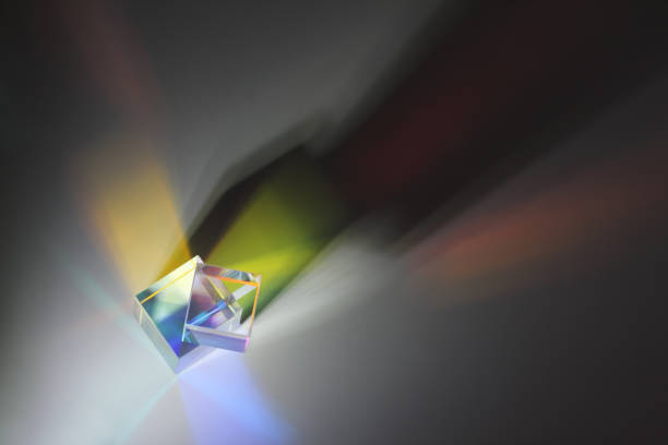 Two prism cubes are on top of each other, refract the light and cast a long side shadow. Top view to the surface