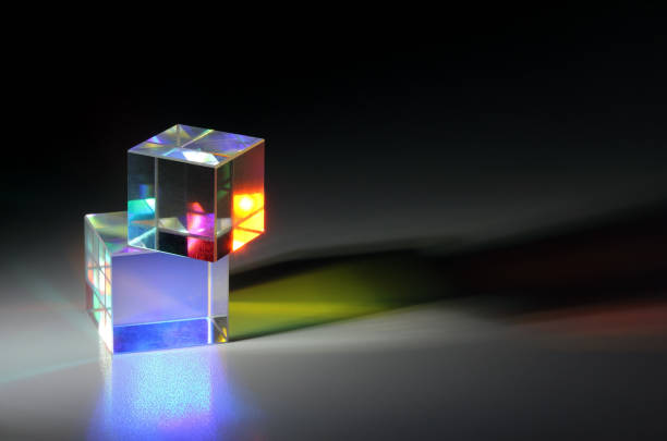 Two bright luminous prism cubes refract light in different colors Two bright luminous prism cubes refract light in different colors. On a dark background facet joint photos stock pictures, royalty-free photos & images