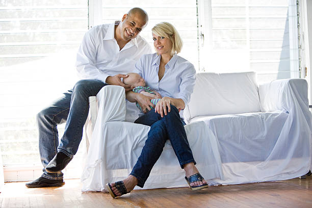 istock Parents with sleeping baby on sofa in sunny home 119907832