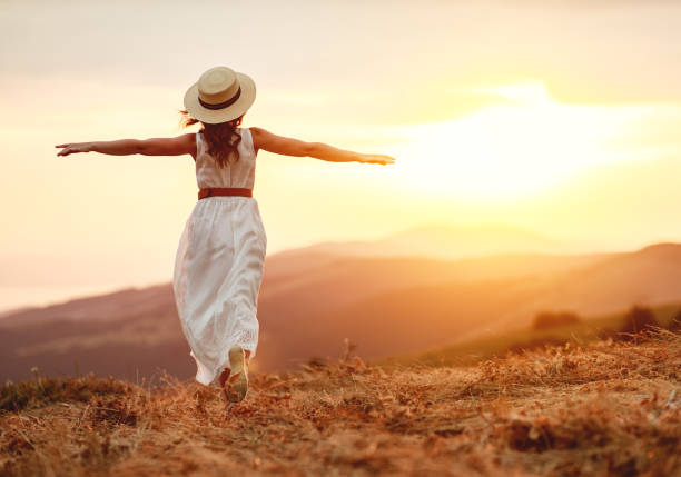 istock Happy woman standing with her back on sunset in nature 1199082135