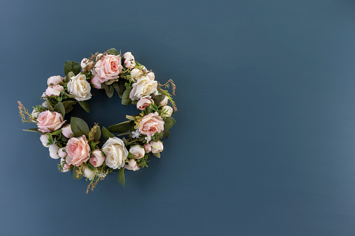 Corona de rosas rosas y blancas sobre un fondo azul liso - copia espacio derecha - círculo de flores plana estaba photo