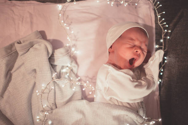 neonato dorme alla luce delle ghirlande festose - baby santa claus christmas sleeping foto e immagini stock