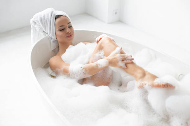 młoda wspaniała kobieta biorąca kąpiel bąbelkową - bathtub women naked human face zdjęcia i obrazy z banku zdjęć