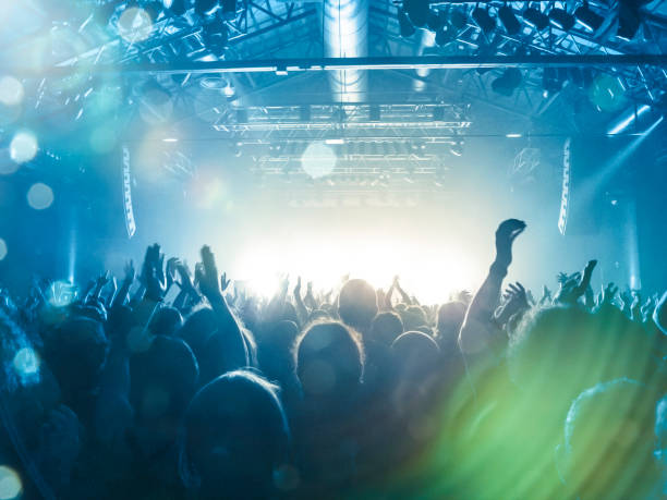 Live music crowd Concert spectators in front of a bright stage with live music club concert stock pictures, royalty-free photos & images