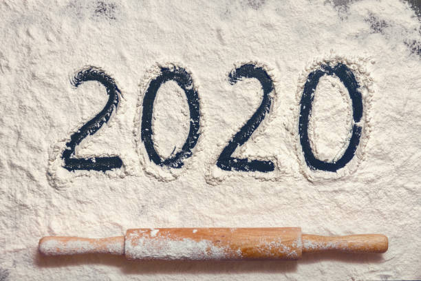 istock numbers 2020 paint on flour table and Christmas tree with confetti from white dough and rolling pin 1199093865