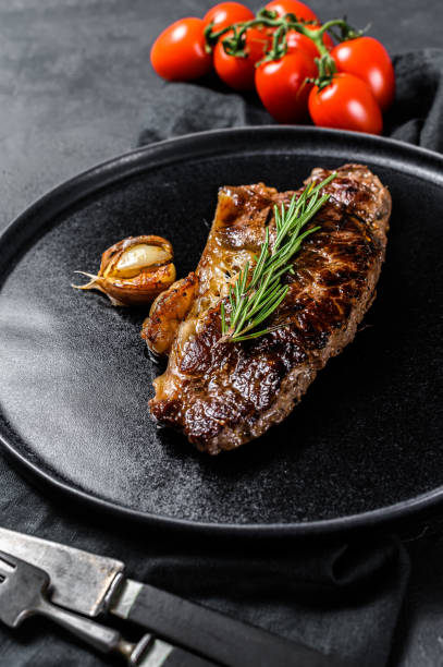 istock Beef strip loin steak on black background.  Marble premium beef 1199096741