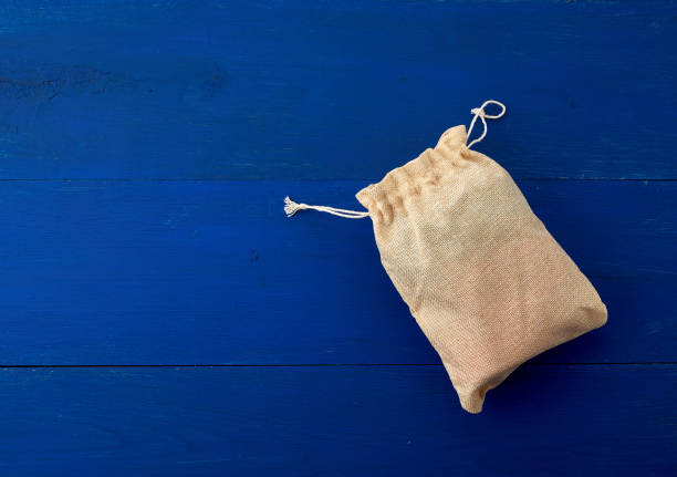 istock small full canvas bag with ties, blue wooden background 1199096900