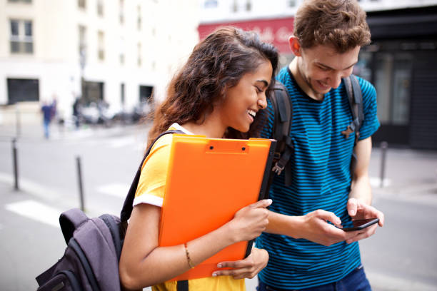 istock happy college students looking at cellphone in city 1199097292