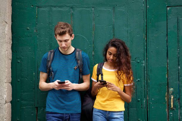 male and female students looking at mobile phone with serious expression
