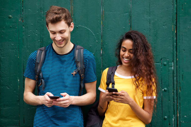 istock male and female students looking at mobile phone with happy expression 1199097312