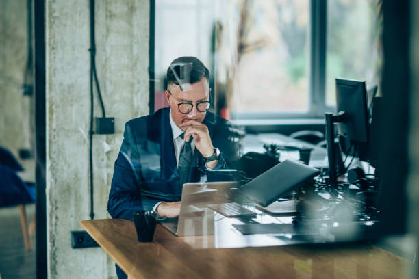 istock Thoughtful businessman in office working on laptop. 1199100456