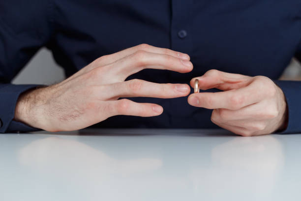 istock Young man is taking off the wedding ring. Close up view. Divorce concept 1199103029