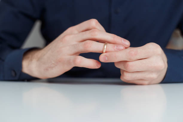 istock Young man is taking off the wedding ring. Close up view. Divorce concept 1199103031
